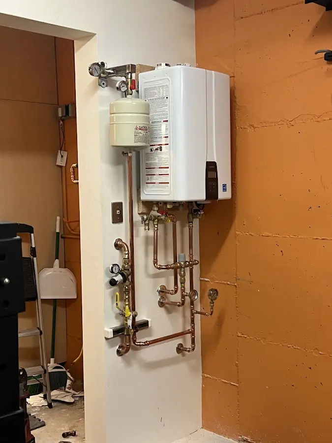 Plumbing technician inspecting water heater connections in Chester Heights